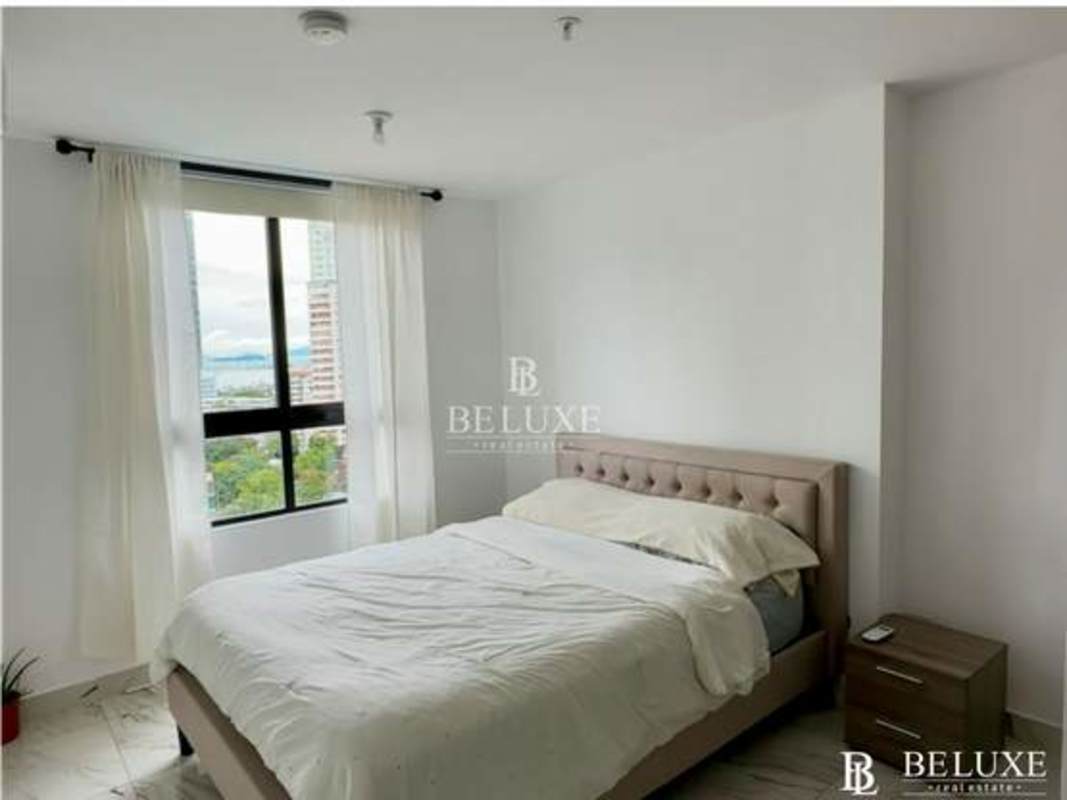 Furnished bedroom with large windows, closet, AC, and city view at PH The Gray in Panama City