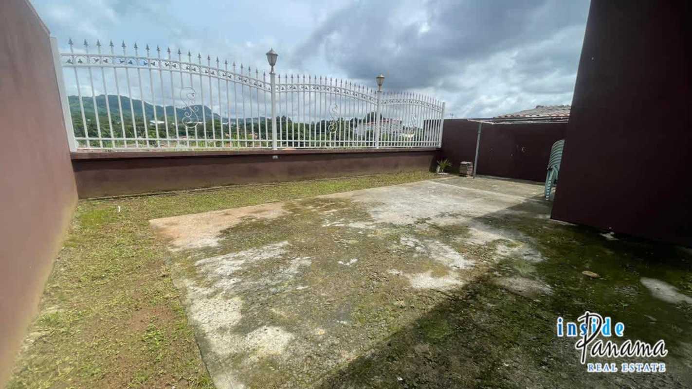 Covered carport with tiled floor and secure gate at house in Residencial San Remo Panama