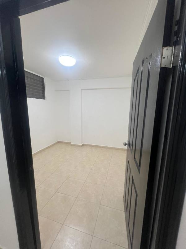 Third bedroom with beige tile floor white walls and black door Panama City