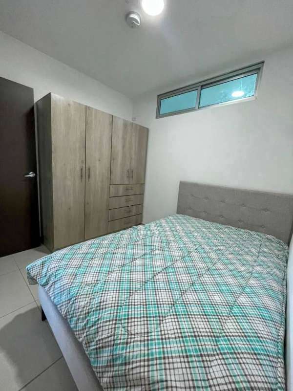 Small bright bedroom with tiled floor, window, and bed in Panama rental