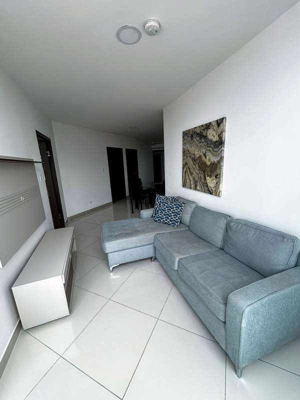 Modern living room with gray sectional sofa wall art white tile Costa del Este apartment