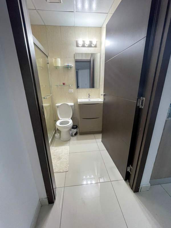 Clean modern shared bathroom glass shower beige tile Panama rental