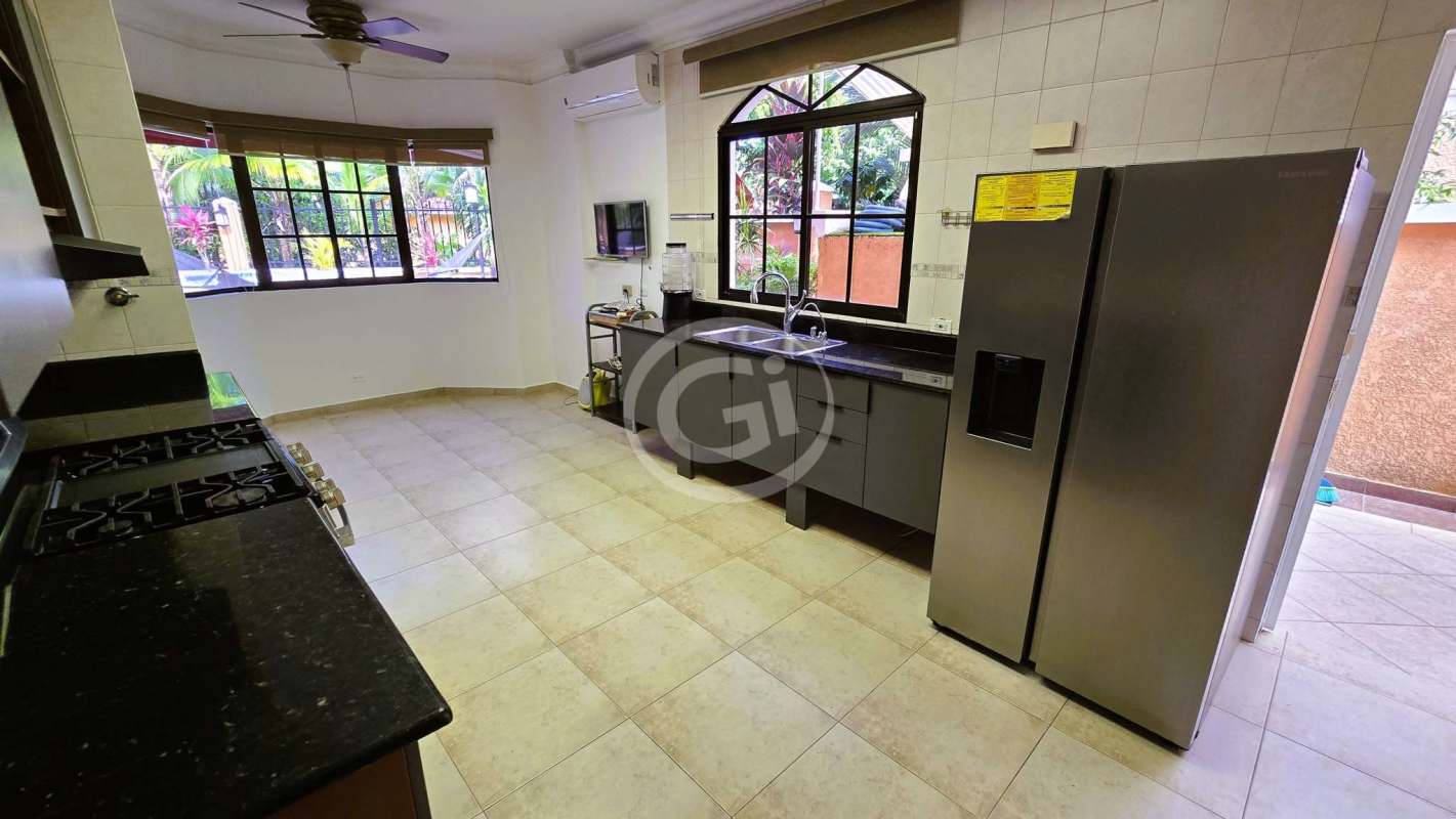 Modern kitchen with granite countertops, black appliances, large windows in house for sale Clayton Panama