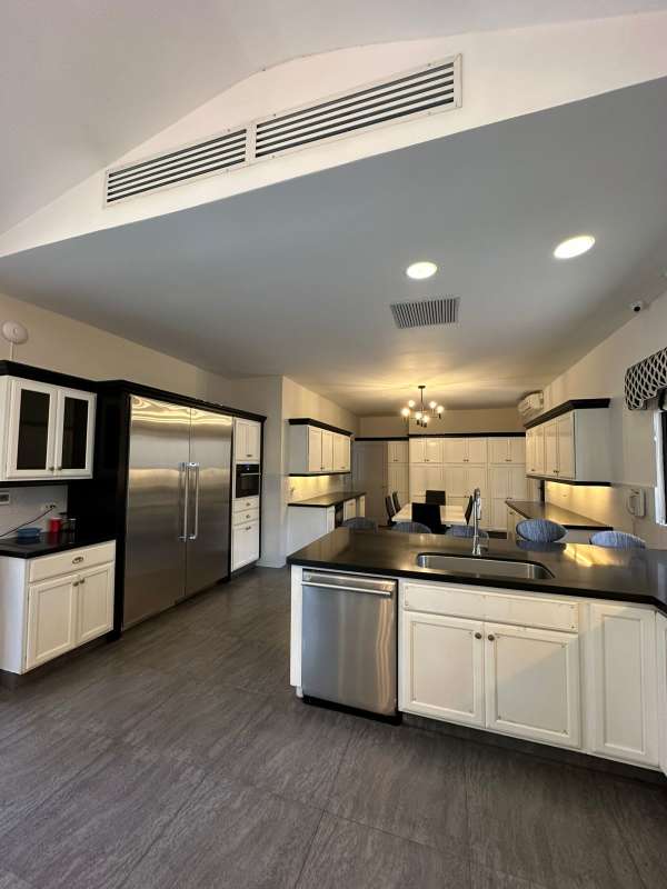 Remodeled kitchen with island granite counters and stainless appliances at PH Antigua Costa del Este Panama