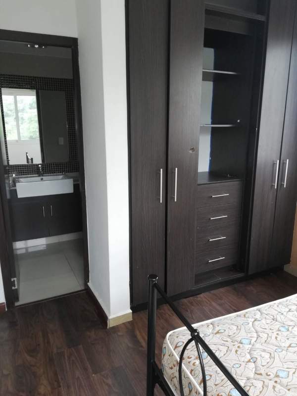 Bedroom with dark wardrobe and attached bathroom with mosaic tiles PH Urbis Panama apartment
