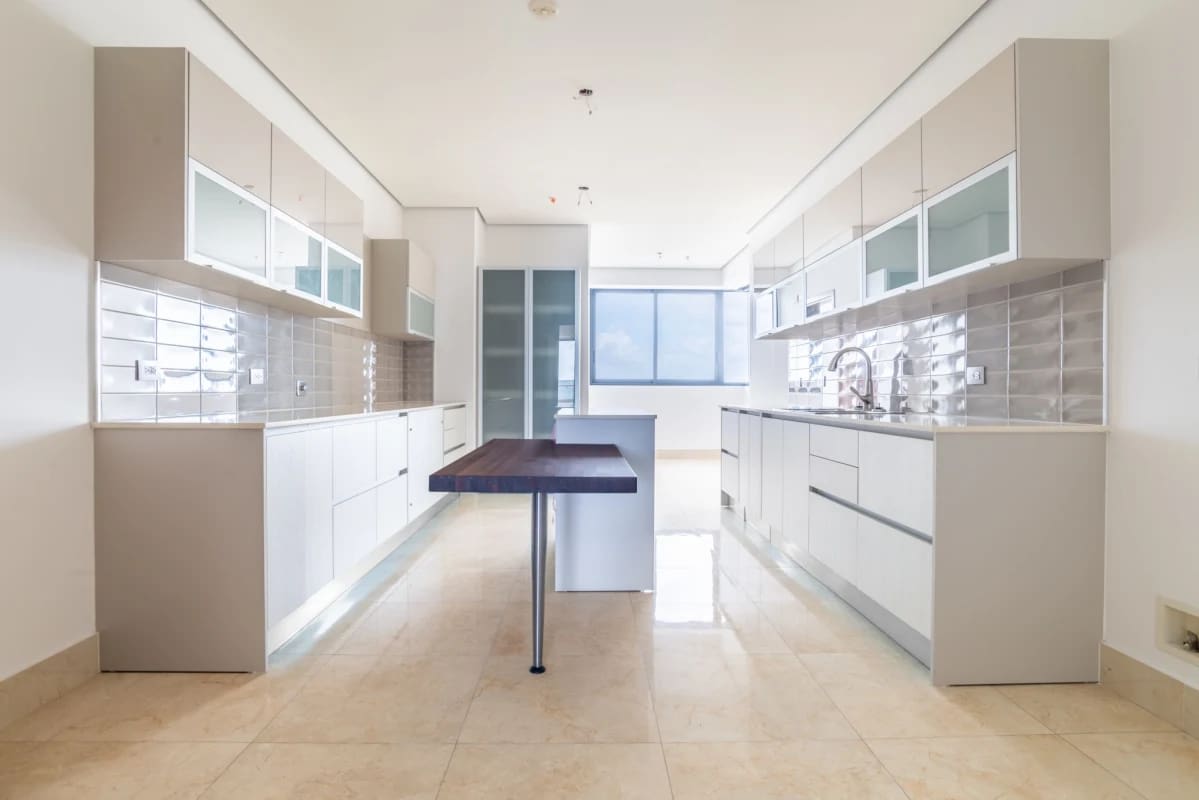 Galley kitchen glossy cabinetry center island large window PH Matisse Costa del Este Panama