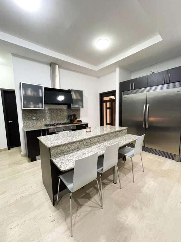 Modern kitchen with granite counters pantry island stainless appliances Costa Sur Panama