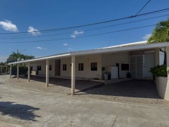 Spacious modern kitchen with island, built-in ovens and red bar stools in Punta Paraíso luxury house