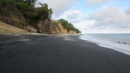 Black sand beach with coastal cliffs and Pacific ocean near San Carlos Panama