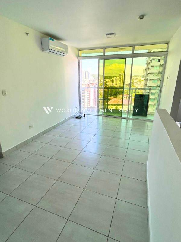 Living area with large window and tiled floor in Metropolitan Park Panama City apartment rental