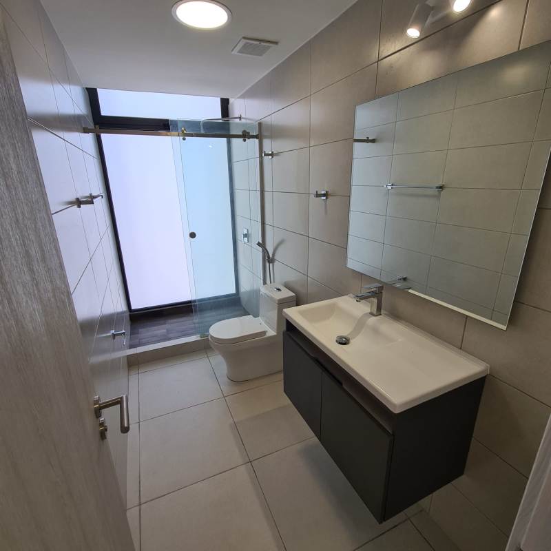 Minimalist bathroom featuring glass-enclosed shower, vanity, and modern fixtures in Coco Place Coco del Mar