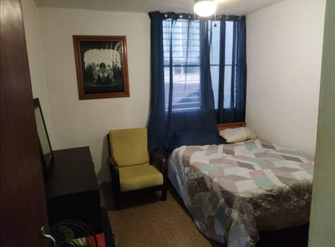 Bedroom with bed, blue curtains, closet and large window with city view in Carrasquilla rental Panama City