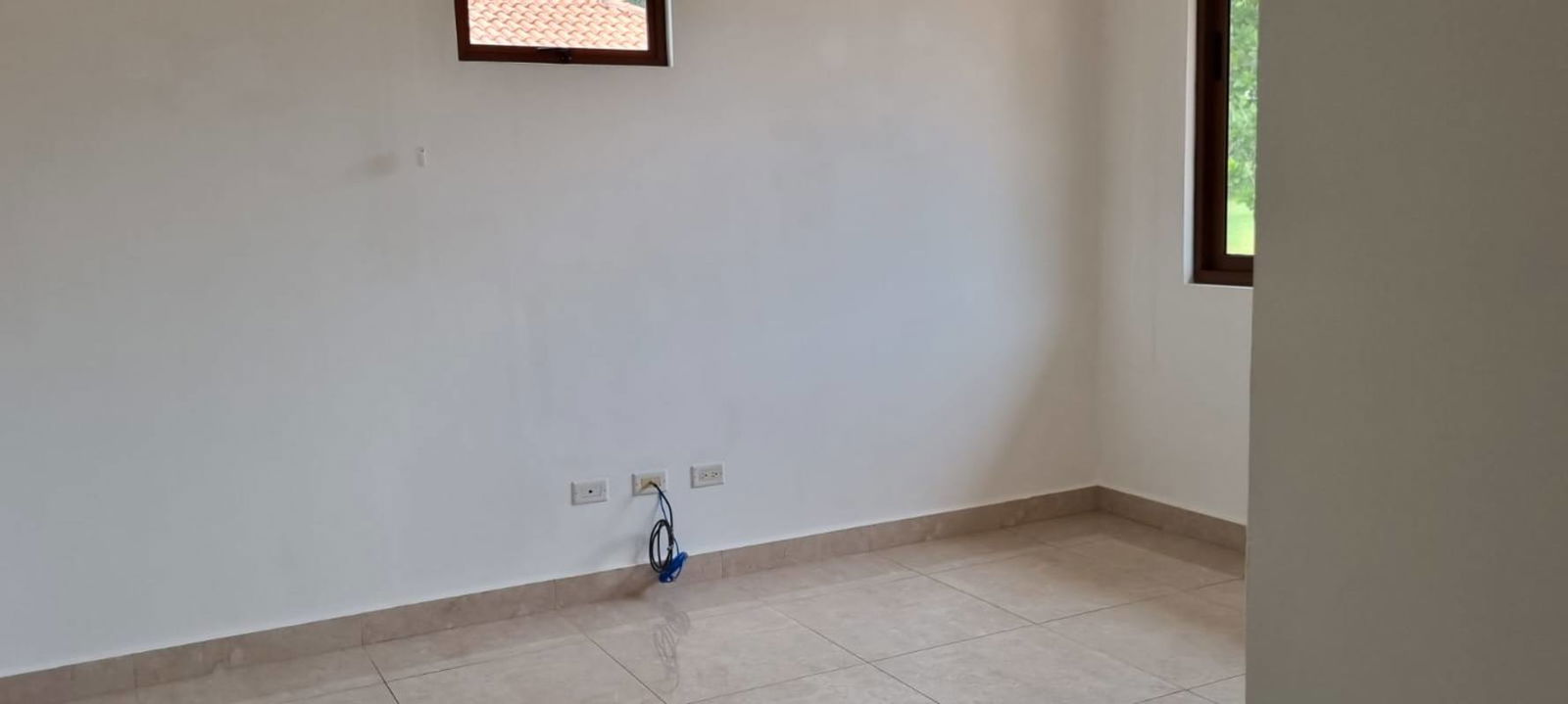 Living room with large windows, glass doors, AC unit, ceiling fan facing garden in Clayton residence Panama