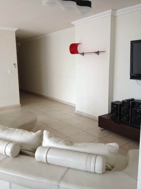 Living room with white sectional sofa, wall-mounted TV, entertainment center PH Onyx Panama City