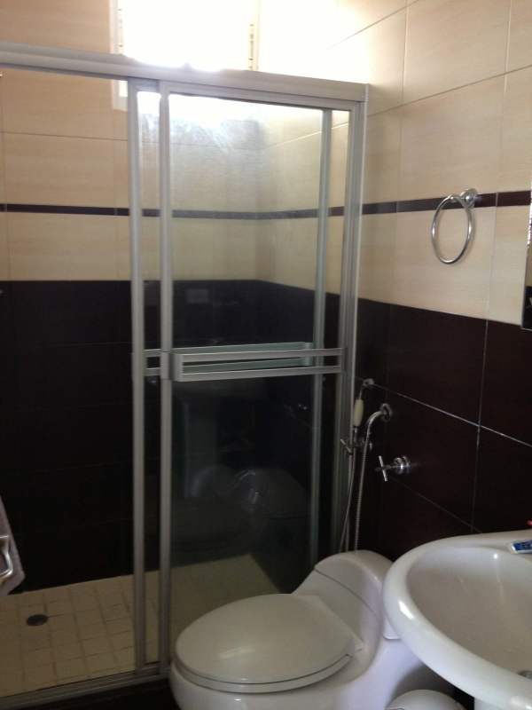 Bathroom with walk-in shower, tile walls, pedestal sink in PH Onyx El Cangrejo Panama