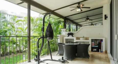 Covered balcony with seating overlooking garden in Puntarena Loft Buenaventura Panama
