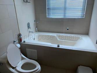 Spacious living room with large glass doors opening to ocean view terrace at Playa Blanca Panama