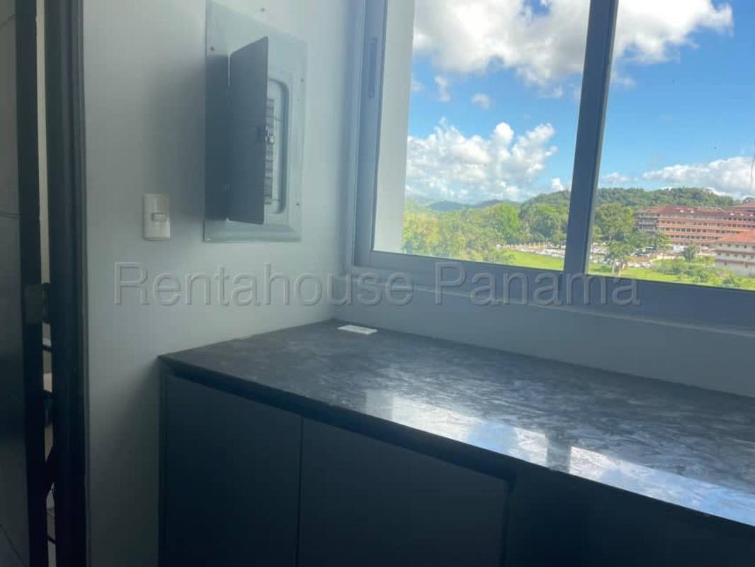 Kitchen with granite countertop, white cabinetry and appliances at Clayton Park apartment for rent in Panama