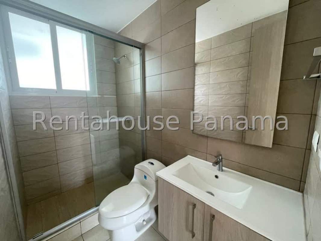 Bathroom with glass shower enclosure, modern sink and mirror in Clayton Residences Panama City