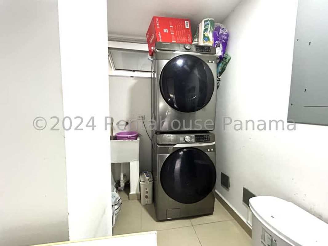 Open living and dining area with floor-to-ceiling glass doors, modern furnishings in Costa Sur home for rent Panama