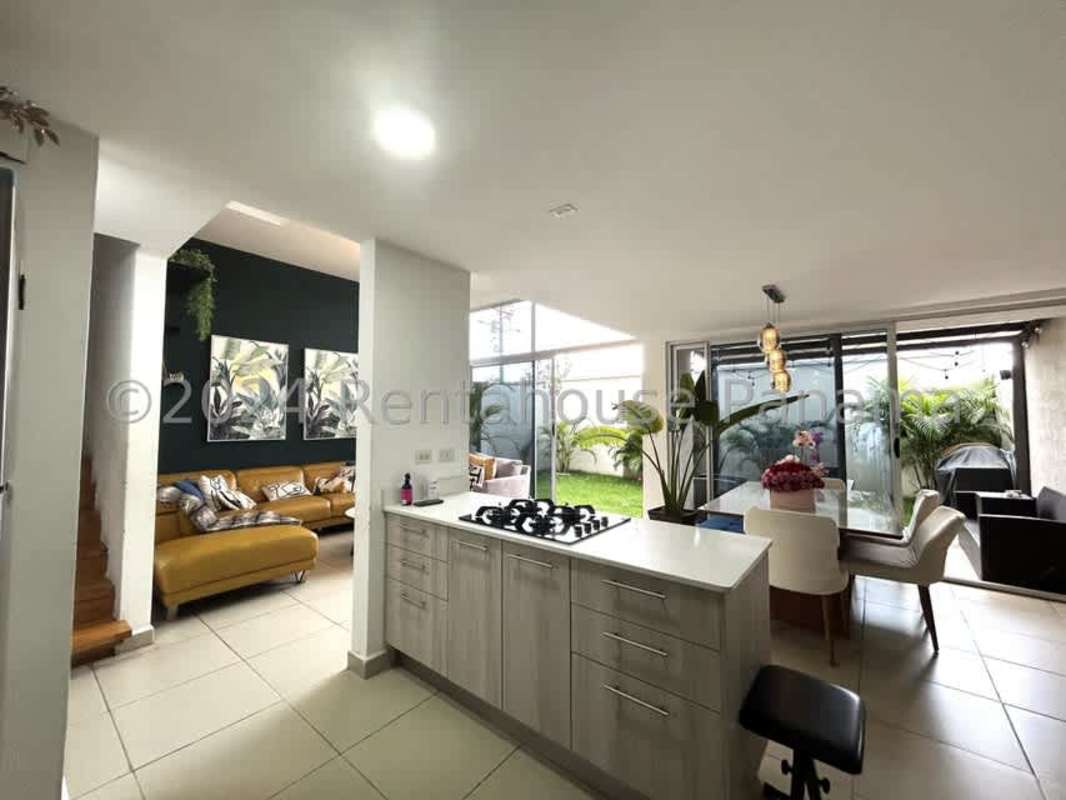 Covered outdoor patio with wicker furniture, barbecue and green garden in Costa Sur Panama