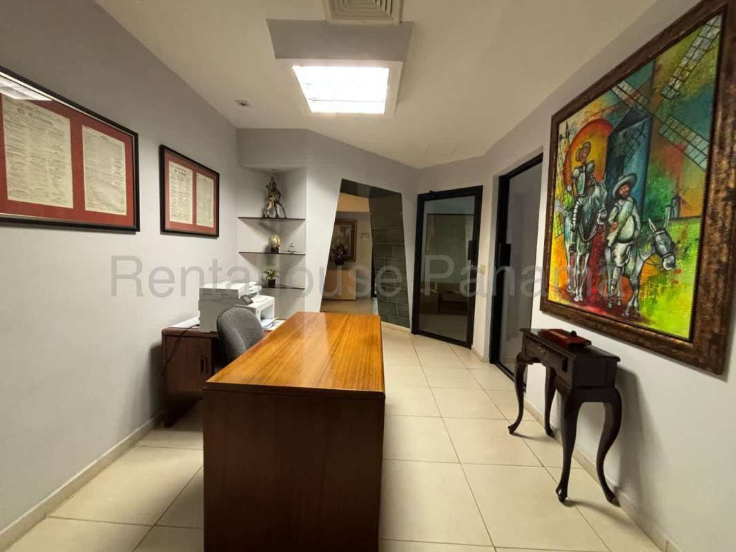 Reception area with desk, wall art, and waiting chairs in Obarrio Center