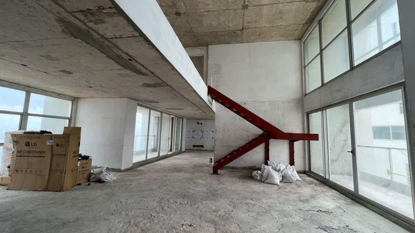 Unfinished double-height interior with floor-to-ceiling window and mezzanine Trump Punta Pacifica