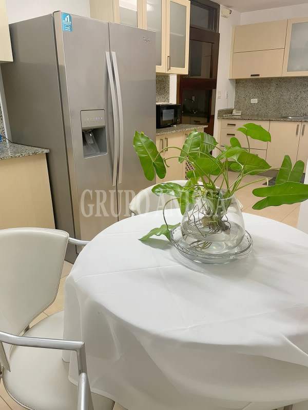 Kitchen with stainless steel refrigerator, dining area and modern finishes at PH Parque del Mar