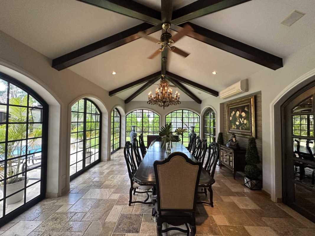 Elegant Mediterranean dining room with vaulted ceiling, large windows, chandelier in luxury mansion Panama