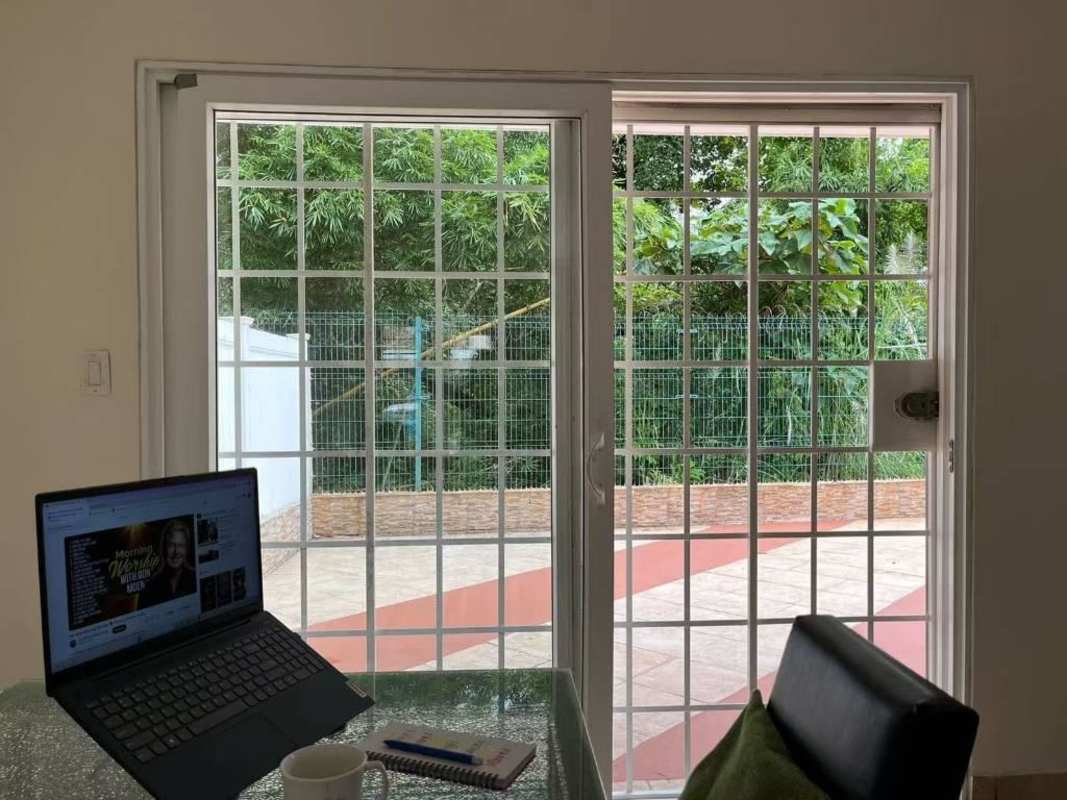 Home office or dining area with sliding glass doors opening to patio and garden in PH Everest Brisas del Golf