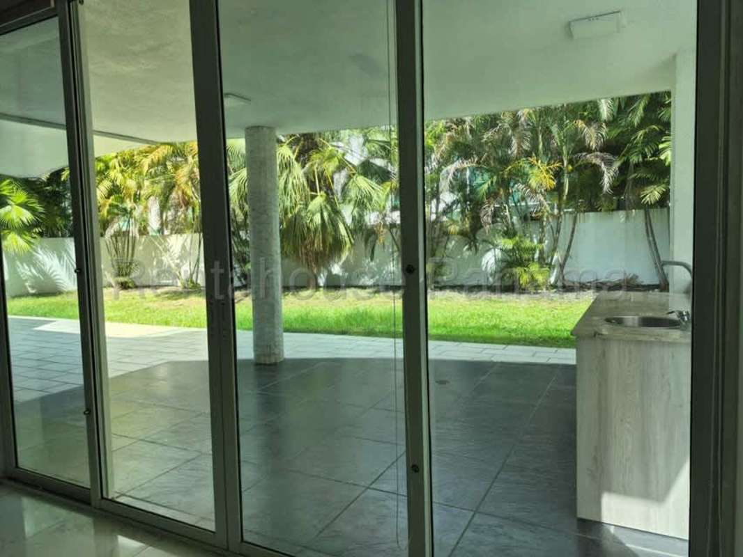 Large covered terrace with outdoor kitchenette and lush garden in Costa Sur Panama luxury house