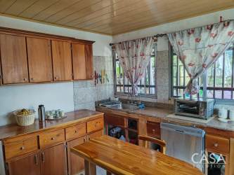 Spacious traditional kitchen with wooden cabinets, granite counters, appliances in mountain house Boquete