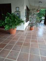Entry with large windows, ceramic floor tiles, and wooden door at countryside house Panama
