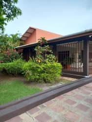 Secure driveway entrance with tiled roof cover and parking at house San José Panama