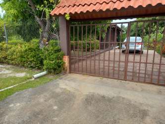 Covered porch area with tiled floors, potted plants, and wall art at country house for sale San José Panama