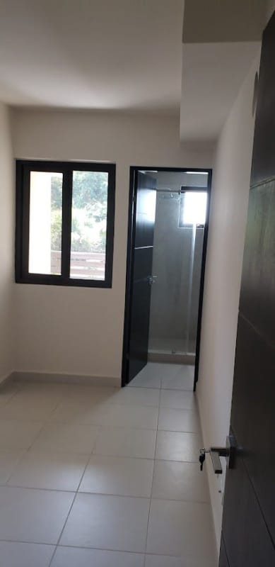 Bedroom with large window and private bathroom Embassy Village Panama