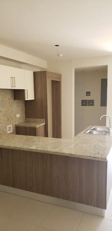 Kitchen with granite countertop and wood cabinetry in Embassy Village apartment Panama City