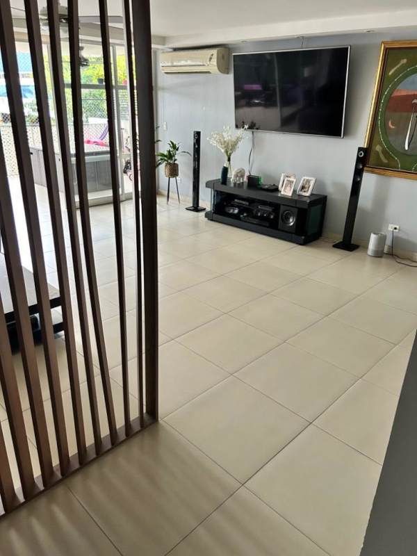 Modern living room with TV, entertainment center, and partition in PH Diplomático Panama