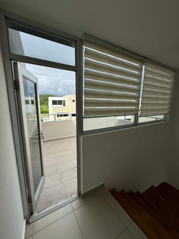 Bright living room with double height ceiling, large windows and modern furniture in Costa Sur Village Panama City