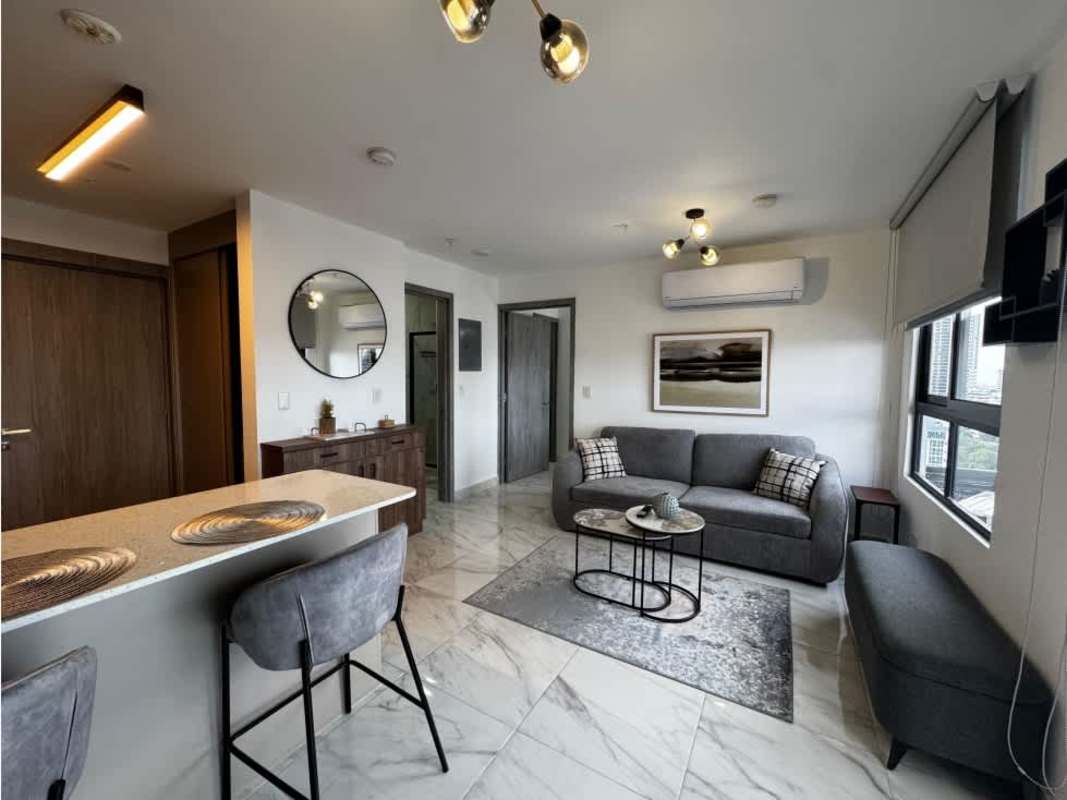 Open plan living room furnished with sofa bed, TV, balcony at PH The Gray Panama