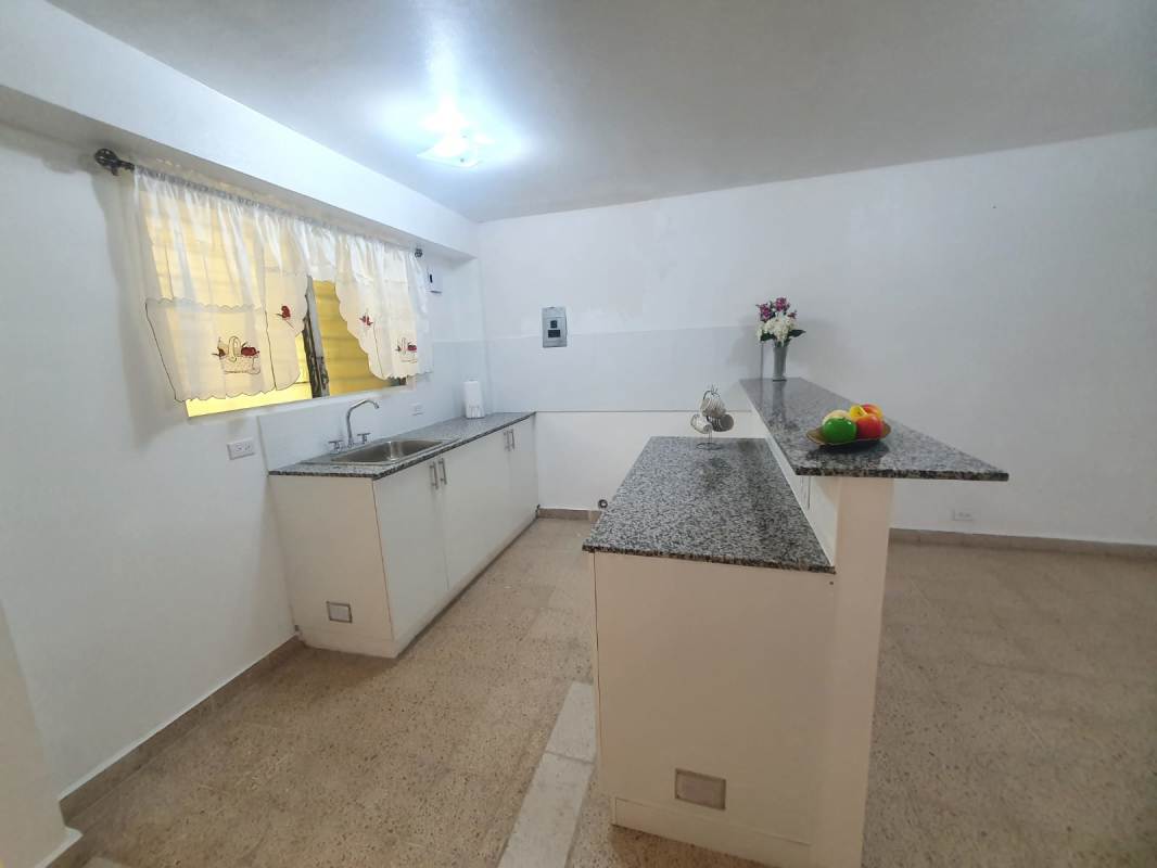 Modern kitchen with granite countertop, white cabinets, window and breakfast bar in Bella Vista apartment rental