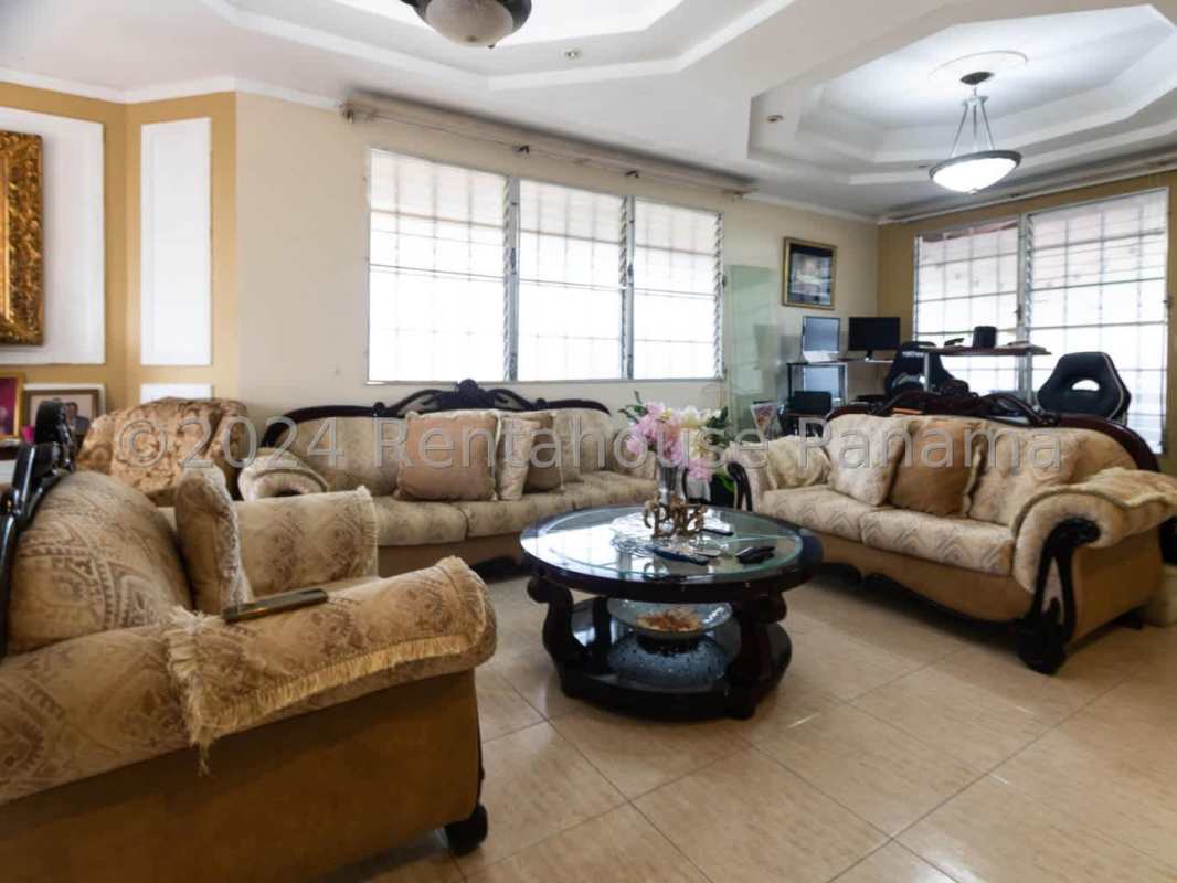 Traditional style spacious living room with tile floors and tray ceiling in Panama City house