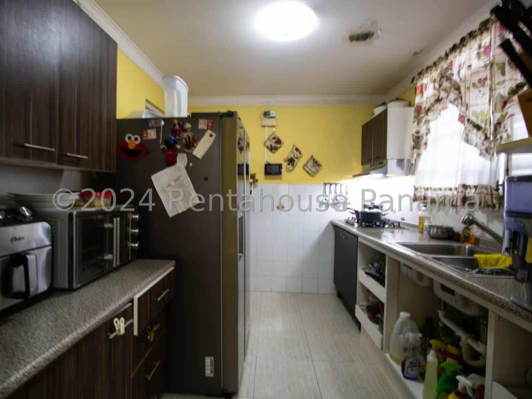 Covered terrace patio with dining set, ceiling fans, and garden view in Brisas del Golf Panama