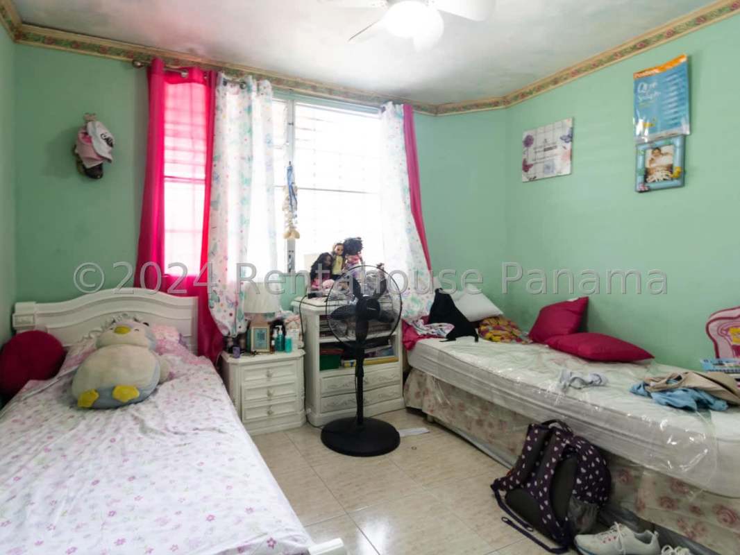Traditional bedroom with closet, natural light, and teal bedding in Panama City suburban home