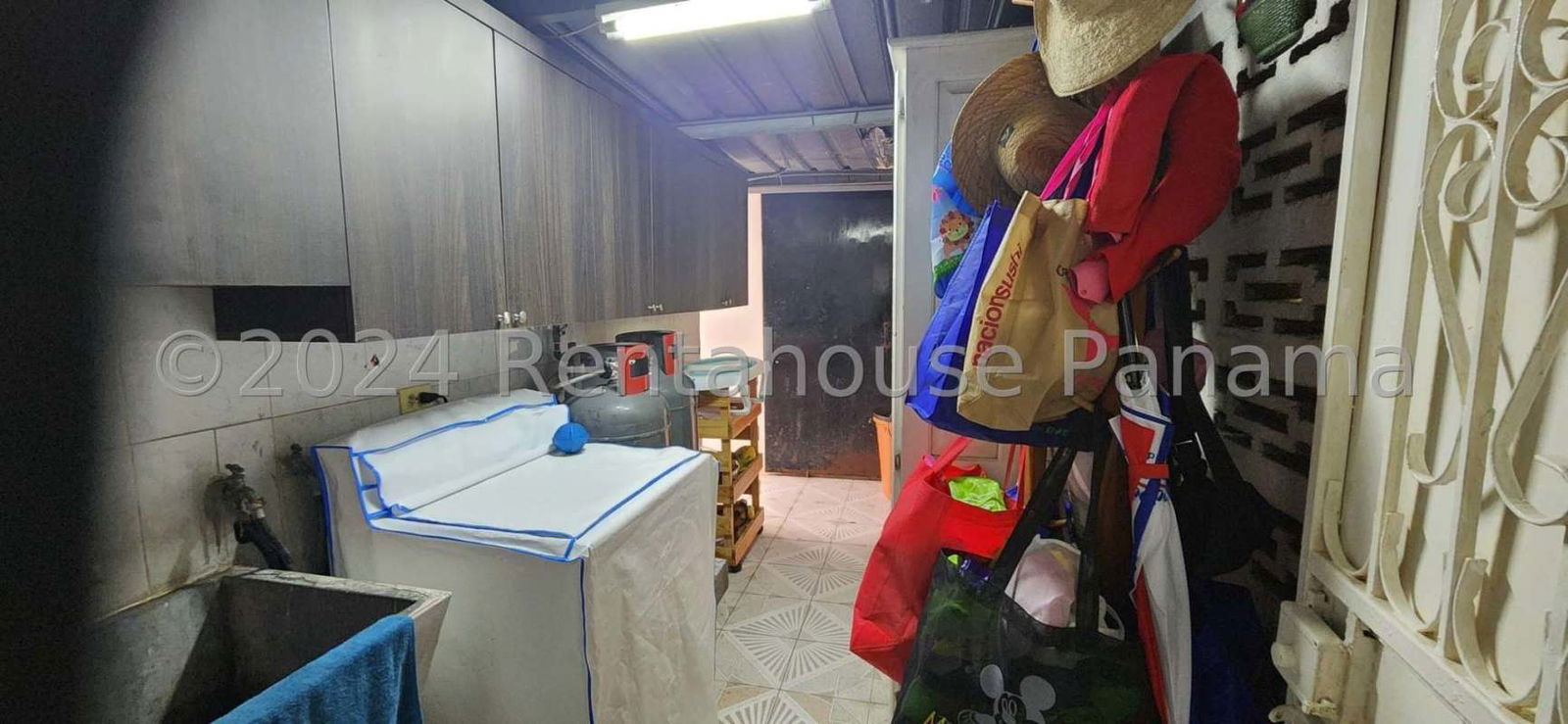 Laundry area with washing machine, utility sink and cabinets Panama house