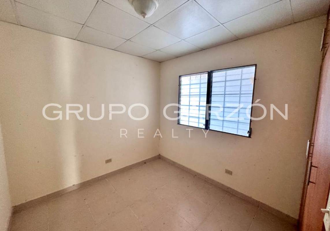 Compact kitchen with granite counters and wooden cabinets in house for sale PH Brisas del Lago