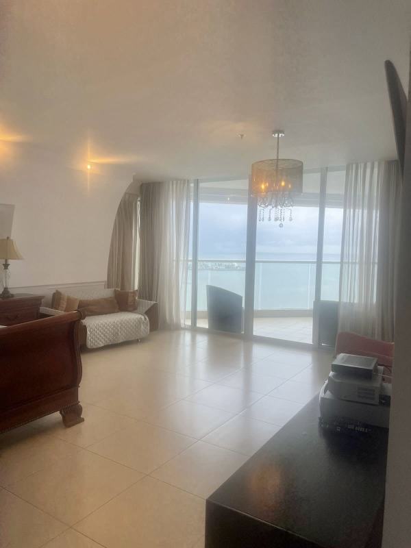 Open-plan living with chandelier, glass staircase, tile floor PH Yacht Club Avenida Balboa