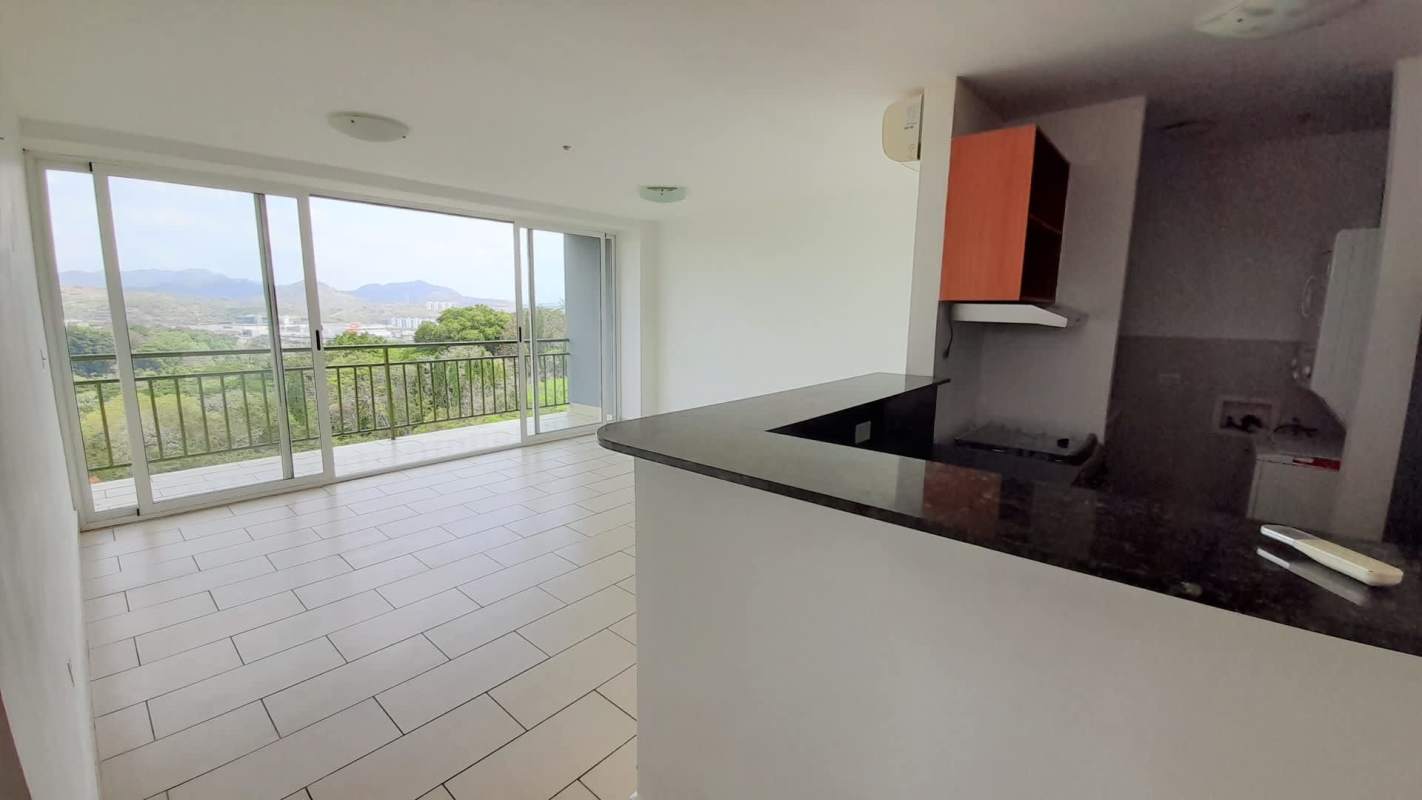 Open living-dining area with balcony overlooking mountains and open kitchen in PH Met View