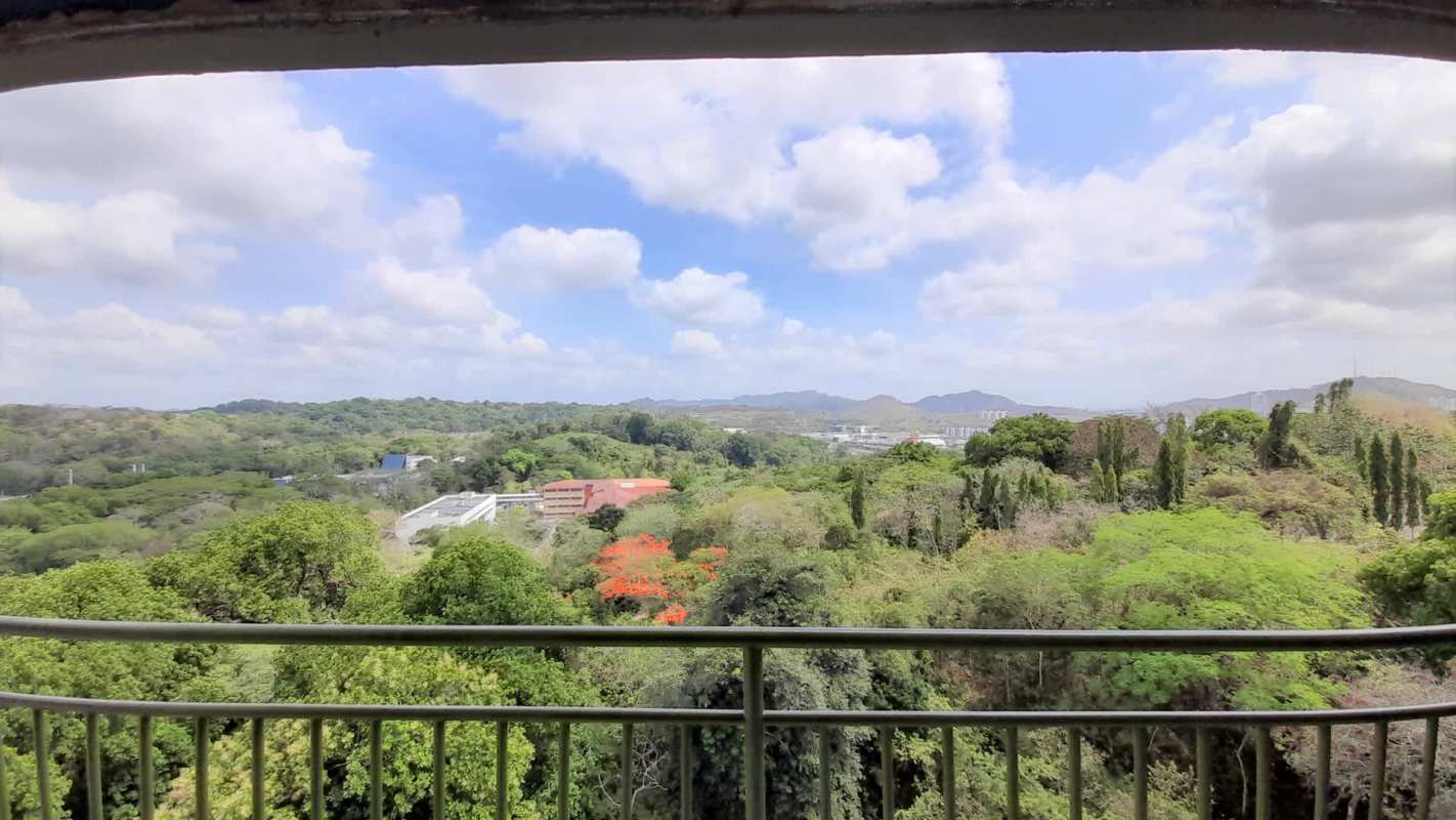 Balcony view with lush greenery and distant hills from PH Met View Towers Panama