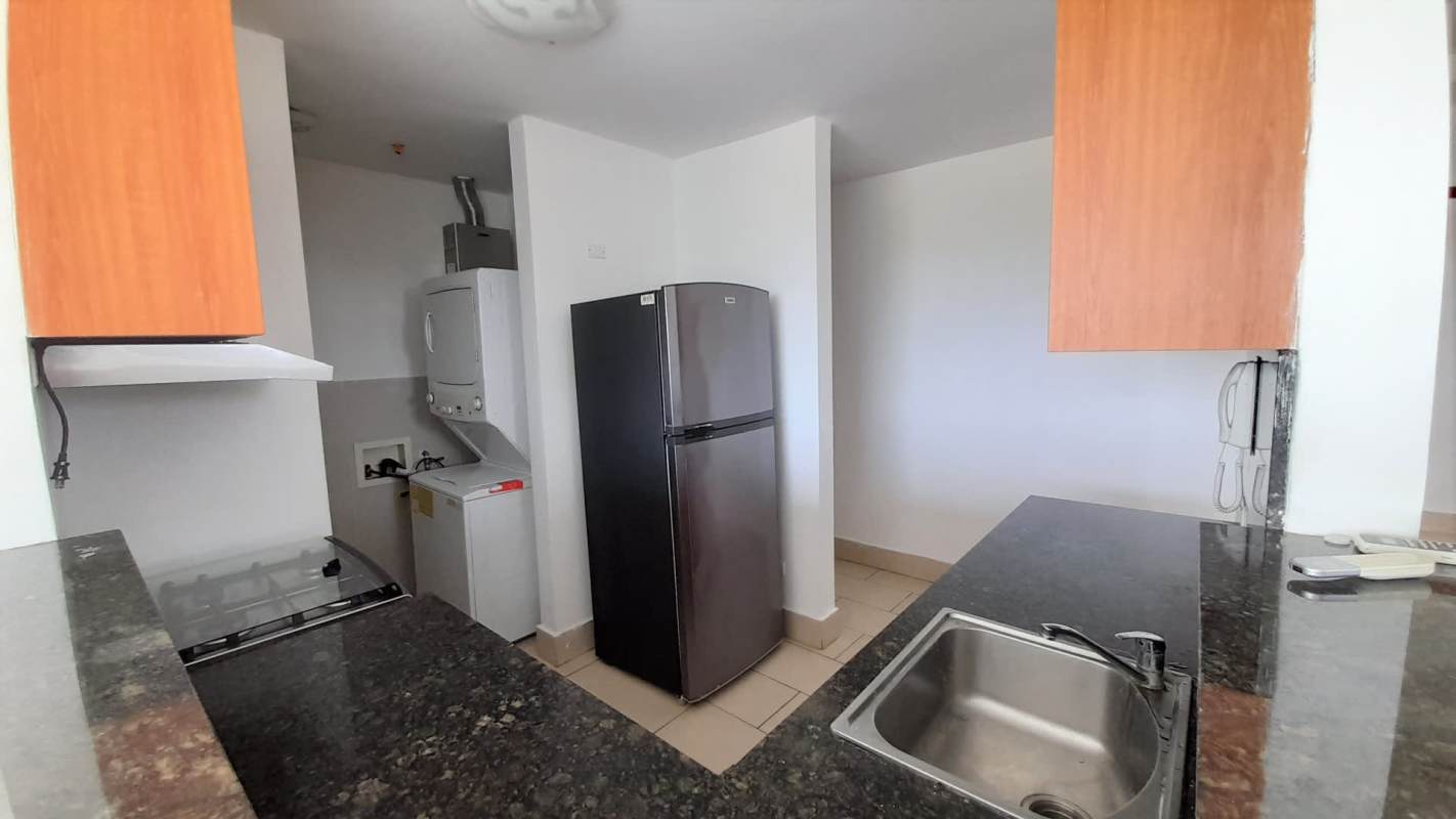 Kitchen with granite countertops, appliances, laundry area at PH Met View Towers in Panama City